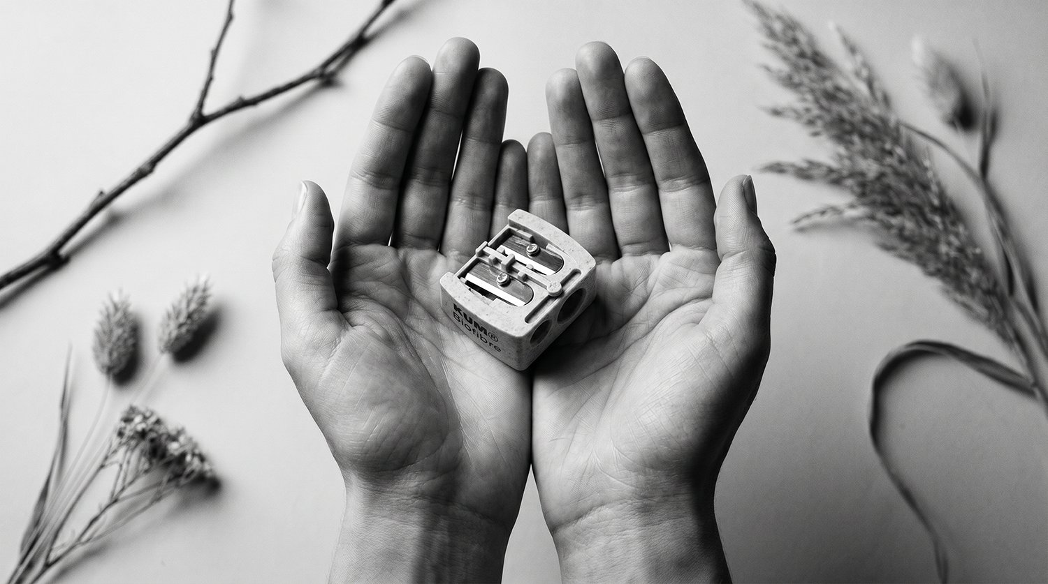 Two open hands presenting a KUM Biofibre sharpener